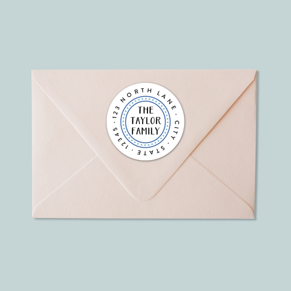 A light pink envelope with a white circular label on the top right corner displaying the text "THE TAYLOR FAMILY CITY STATE ST. LOUIS".