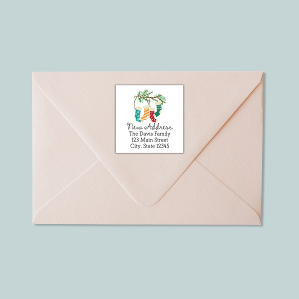 A light pink envelope with a white label on it, featuring a Christmas-themed design.