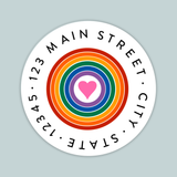 A circular white label with a rainbow-colored heart in the center, surrounded by the text 