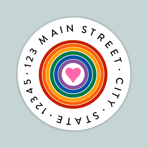 A circular white label with a rainbow-colored heart in the center, surrounded by the text "MAIN STREET CITY STATE" in a circular pattern.