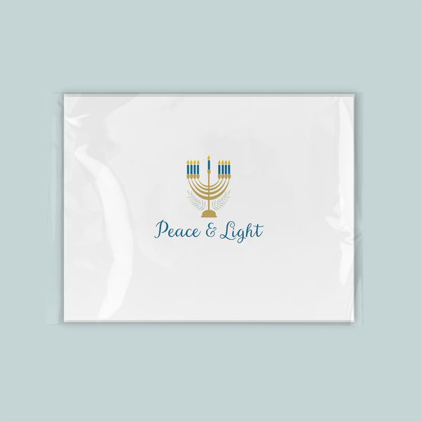 A white rectangular card with a stylized design of a menorah and the text "Peace & Light" printed on it.