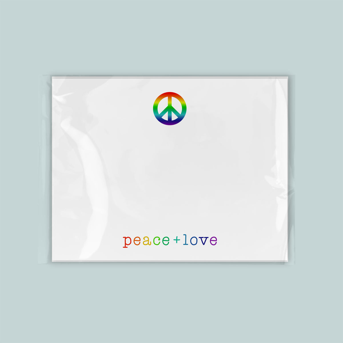 A white piece of paper with a peace symbol and the text "Peace + love" printed on it.