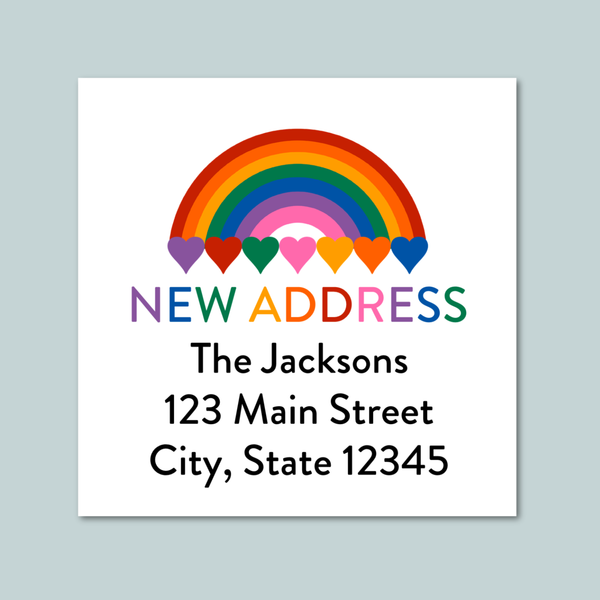 The image is a white square with a rainbow graphic and the text "NEW ADDRESS" in the center. Below the rainbow graphic, the text reads "The Jacksons 123 Main Street City, State 12345".