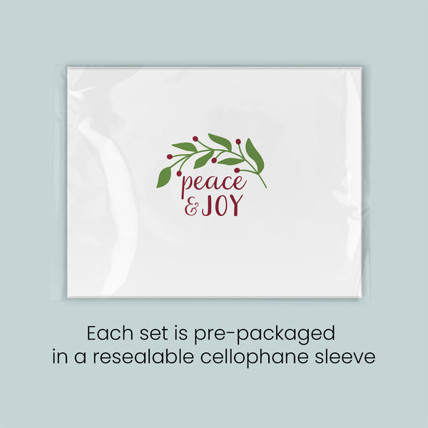 A white rectangular card with a red and green design featuring the text "Peace & Joy" and a wreath of leaves and berries.