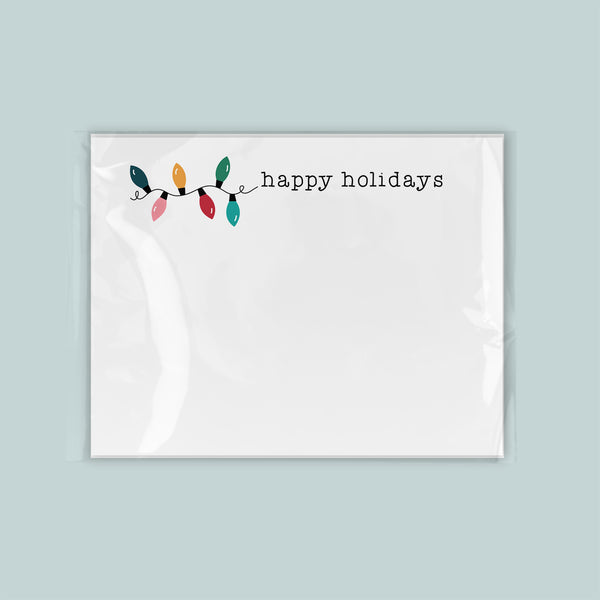 A white card with a festive design featuring colorful lights and the text "happy holidays".