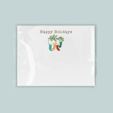 A white greeting card with a festive holiday design featuring a pair of colorful stockings hanging from a branch.