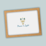 A greeting card with a peace and light theme, featuring a stylized menorah with candles and the text 