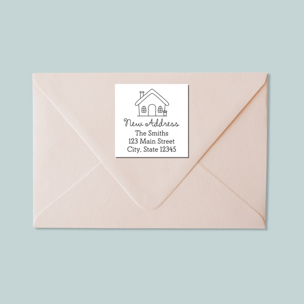 A light pink envelope with a white label that reads "New Address The Smiths 123 Main Street City, State 12345".