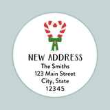 The image is a white circular label with a red and white striped candy cane and a green ribbon, along with text that reads 
