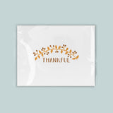 A white rectangular card with a decorative leaf design and the word 