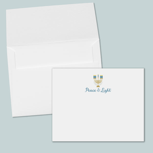 an open white envelope with a printed "Peace & Light" logo on the front.