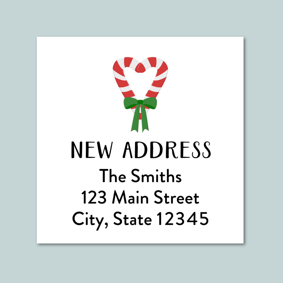 a white square with a red and white striped candy cane and a green ribbon tied around it, along with the text "NEW ADDRESS" and "The Smiths 123 Main Street City, State 12345".