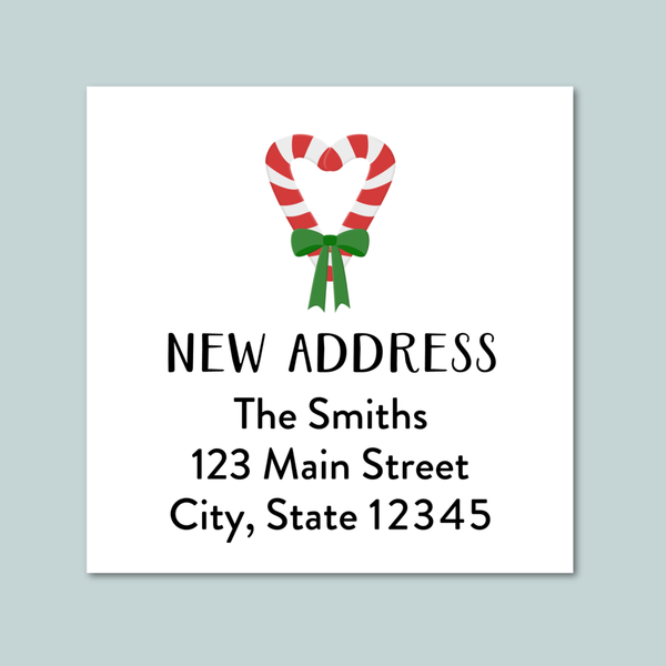 a white square with a red and white striped candy cane and a green ribbon tied around it, along with the text "NEW ADDRESS" and "The Smiths 123 Main Street City, State 12345".