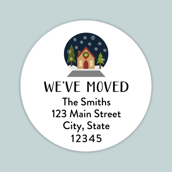 A white circular label with a winter scene and a house, along with the text "WE'VE MOVED The Smiths 123 Main Street City, State 12345".