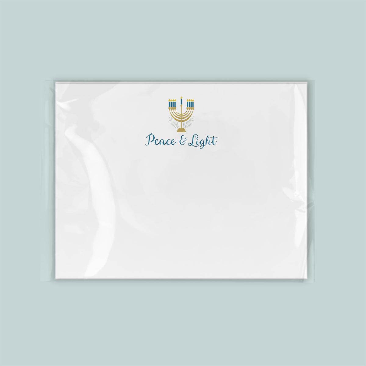 A white envelope with a blue and gold design featuring a menorah and the text "Peace & Light" printed on it.