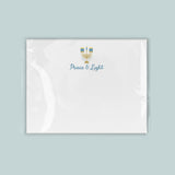 A white envelope with a blue and gold design featuring a menorah and the text 
