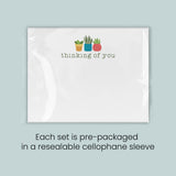 A set of pre-packaged greeting cards, each set in a resealable cellophane sleeve, with a simple design featuring three potted plants and the text 