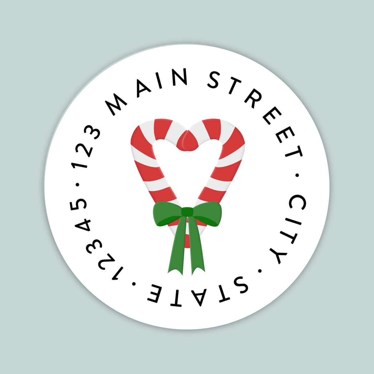 A white circular label with a red and white striped candy cane and a green ribbon bow.