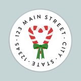 A white circular label with a red and white striped candy cane and a green ribbon bow.
