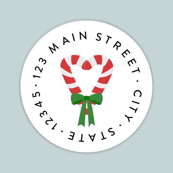 A white circular label with a red and white striped candy cane and a green ribbon bow.
