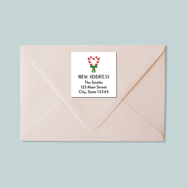 A light pink envelope with a white label that reads "NEW ADDRESS The Smiths 123 Main Street City, State 12345".