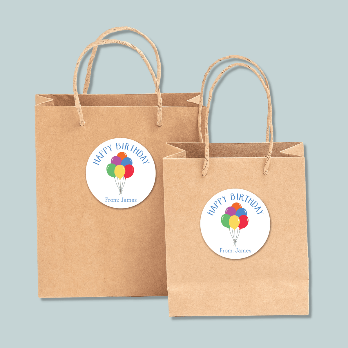 Two brown paper shopping bags with a "Happy Birthday" sticker on them.