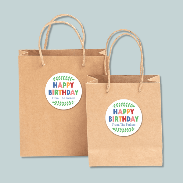 Two brown paper shopping bags with a "Happy Birthday" sticker on them.