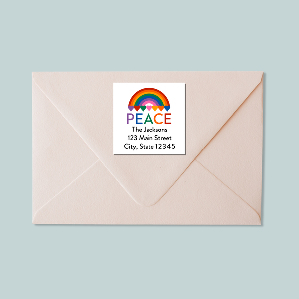 A light pink envelope with a white label that says "PEACE The Johnsons 123 Main Street City, State 12345" and features a rainbow graphic.