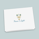 A white greeting card with a stylized graphic of a menorah and the text 