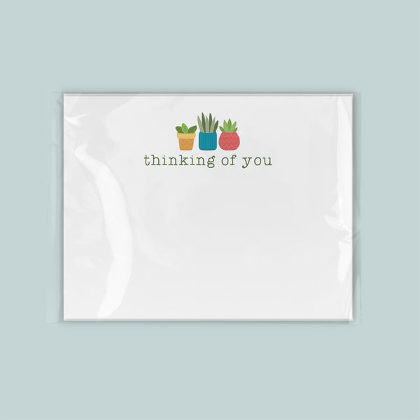 A white card with a message and three potted plants printed on it.