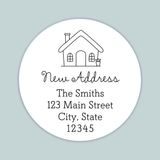 A white circular address label with a house illustration and text providing the address of The Smiths at 123 Main Street, City, State 12345.