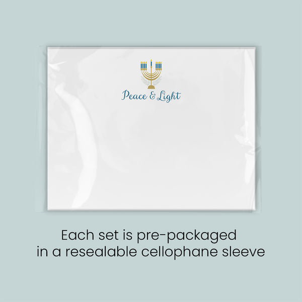 A white rectangular card with a gold and blue design and the text "Peace & Light" printed on it.