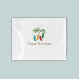 A white greeting card with a festive design featuring colorful Christmas stockings and a pine tree branch.